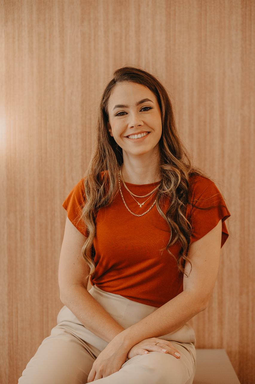 Dra. Marília Dantas, pediatra, sorrindo em seu consultório